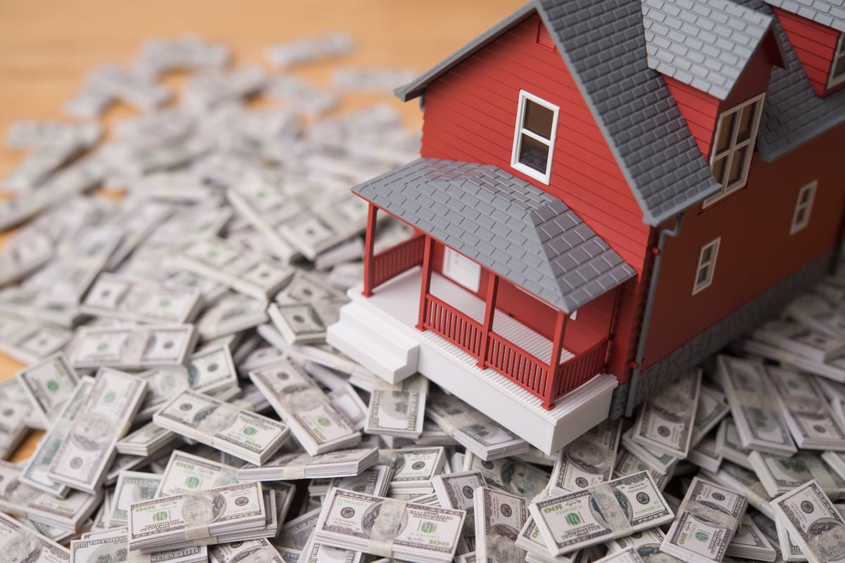 House model on dollar banknotes representing a real estate cash deal and return on investment